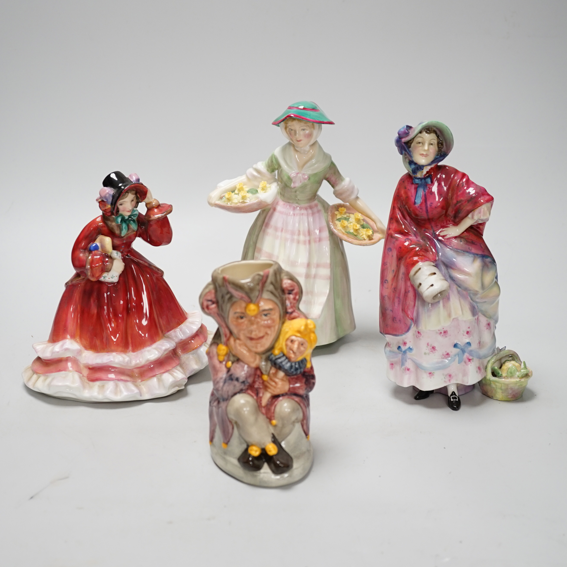 Three Royal Doulton figurines including Christmas Time HN2110 and a character jug, The Jester, the largest 21cm high